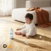 Chai Dung Dịch Lau Sàn Ecovacs Xuất Hiện Trong Bối Cảnh Sinh Hoạt Gia Đình. Khi Bảo Quản Thực Tế, Cần Để Sản Phẩm Xa Tầm Tay Trẻ Em. Chai Dung Dịch Ecovacs Deebot Đặt Trên Sàn Gỗ Trong Phòng Khách Có Trẻ Nhỏ.